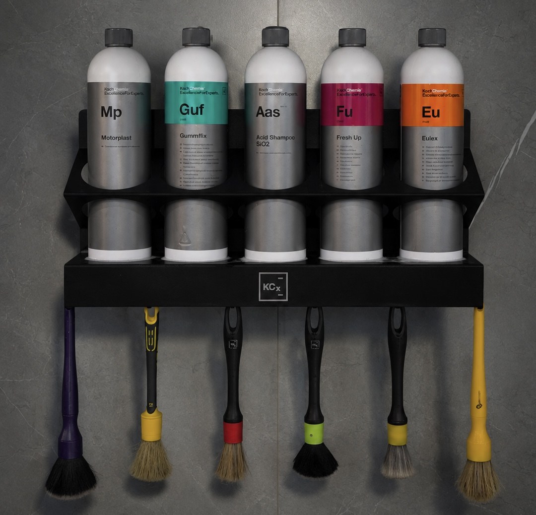 Стойка Koch Chemie с составами и кистями на стене бокса